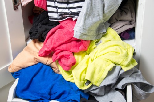 Removal team carrying office furniture from a small upper-floor office